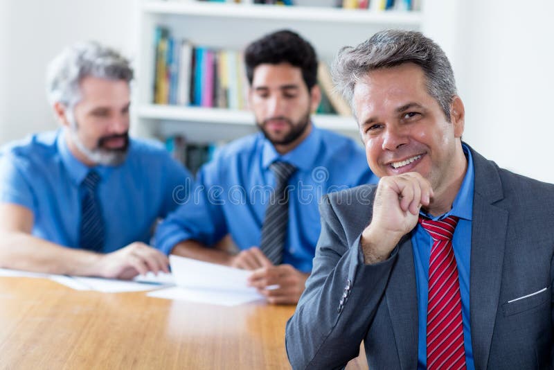 Handsome elderly businessman with motivated team at office royalty free stock image