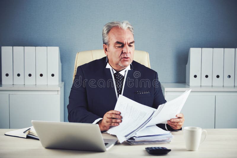 Senior Businessman Looking through Important Documents Stock Photo ...