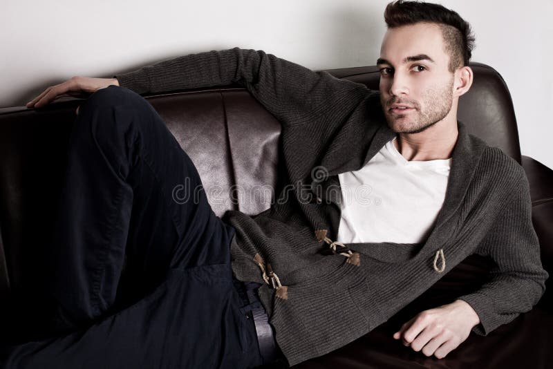 Portrait Of A Stylish Handsome Man On A Leather Sofa. Fashion Shot. Men's  Clothing And Accessories. Stock Photo, Picture and Royalty Free Image.  Image 113310024.