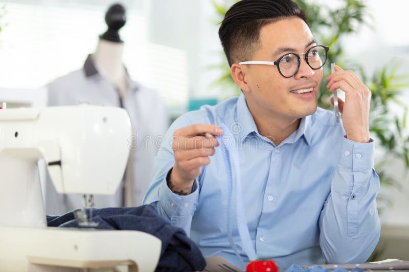 Handsome Fashion Designer Sewing with Sewing Machine Stock Photo
