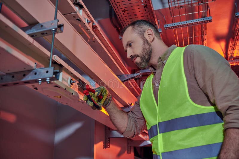 Un profesionist chipeș, concentrat în vesta de siguranță stock photography