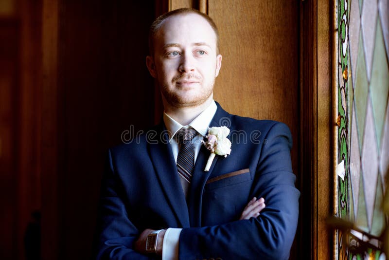 Handsome groom in suit in the hall