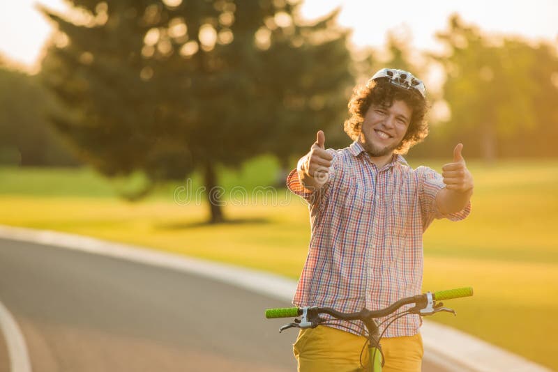 Handsome Guy on Bike Gesturing Thumbs Up. Stock Photo - HanDsome Guy Bike Gesturing Thumbs Up HanDsome Guy Bike Gesturing Thumbs Up Portrait Happy Male Biker Giving Two Thumbs 118649276