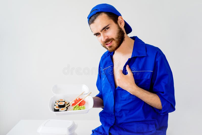 Handsome guy delivering sushi stock image