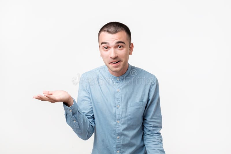 Handsome hispanic guy, looking upside and shrugging his shoulders showing there is nothing he can do with situation. royalty free stock photography Handsome hispanic guy, looking upside and shrugging his shoulders showing there is nothing he can do with situation. royalty free stock photography