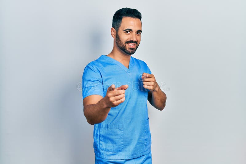 Handsome Hispanic Man with Beard Wearing Blue Male Nurse Uniform Pointing  Fingers To Camera with Happy and Funny Face Stock Photo - Image of excited,  blue: 221158676