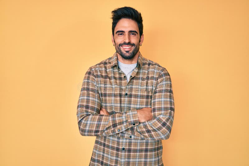 Handsome hispanic man with beard wearing casual clothes happy face smiling with crossed arms looking at the camera
