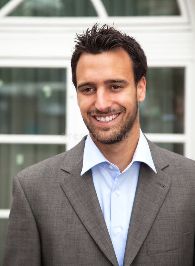 Handsome latin businessman laughing in front of his office