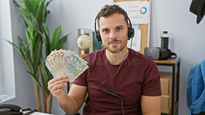Handsome man with beard holding romanian currency in a modern office setting stock image