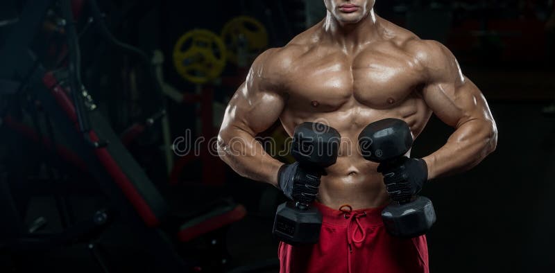 Handsome Man With Big Muscles Trains In The Gym Exercises Stock Photo