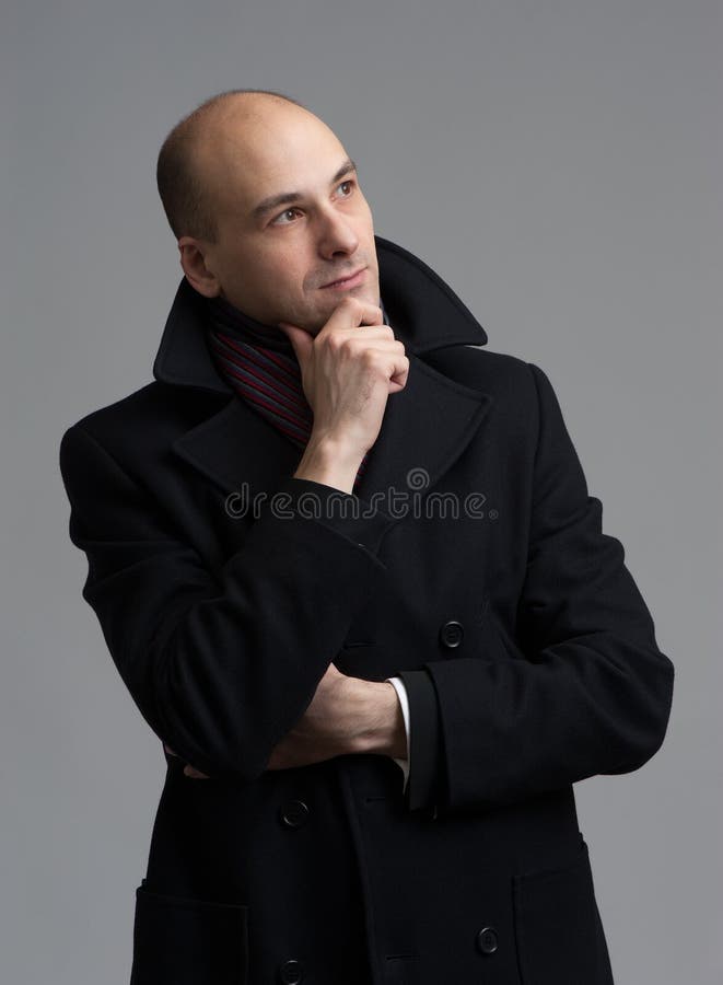 Handsome man in coat thinking