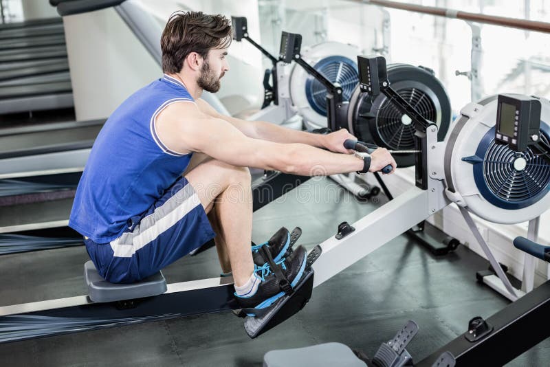 Handsome man doing exercise on drawing machine royalty free stock image Handsome man doing exercise on drawing machine royalty free stock image