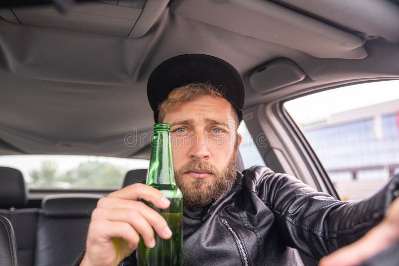 A Handsome Man Drinking Beer while Driving a Car Stock Photo Image of