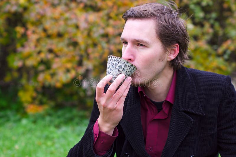 Handsome man drinking tea outdoors