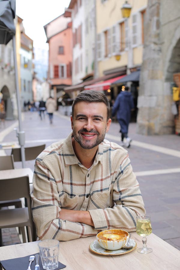 Handsome man eating in European cafe terrace stock photography