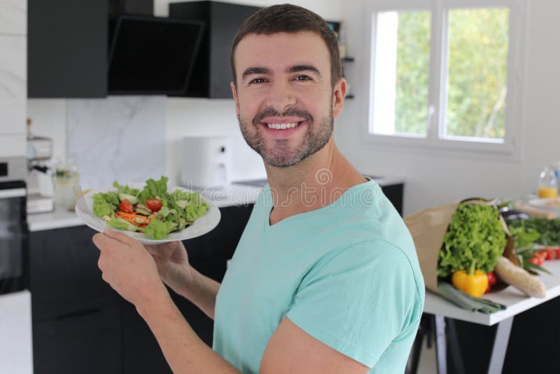 Handsome man eating a healthy salad stock photo