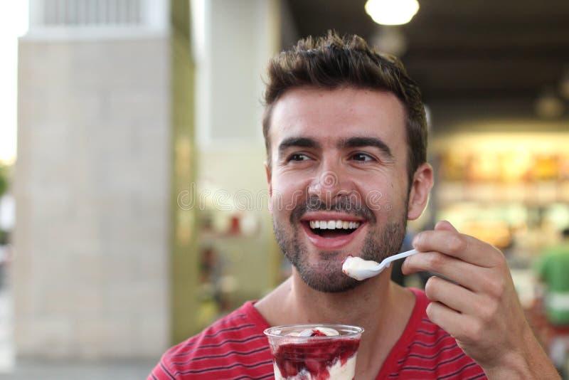 Handsome man eating a yummy ice cream stock photography