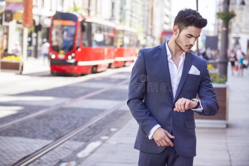 Handsome man elegantly dressed looking at his watch