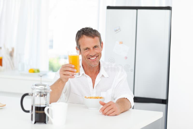 Handsome man having his breakfast in the kitchen
