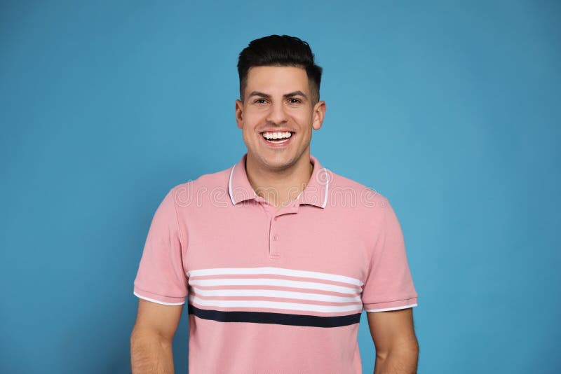 Handsome Man Laughing on Light Blue Background. Funny Joke Stock Image