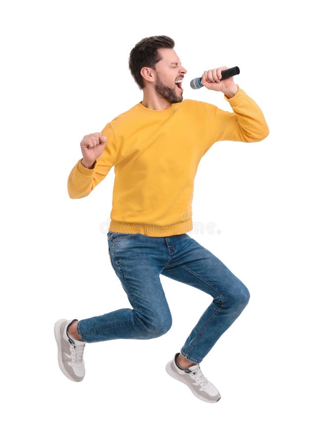 Handsome man with microphone singing and jumping on white background stock photo