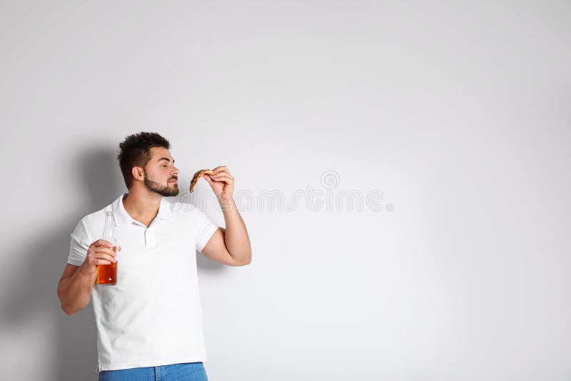 Handsome man with pizza and beer on background, space for text royalty free stock photography Handsome man with pizza and beer on background, space for text royalty free stock photography