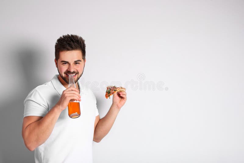 Handsome man with pizza and beer on background, space for text stock image Handsome man with pizza and beer on background, space for text stock image