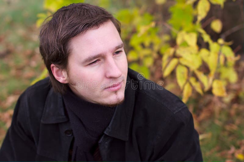 Handsome man portrait in autumn leaves background