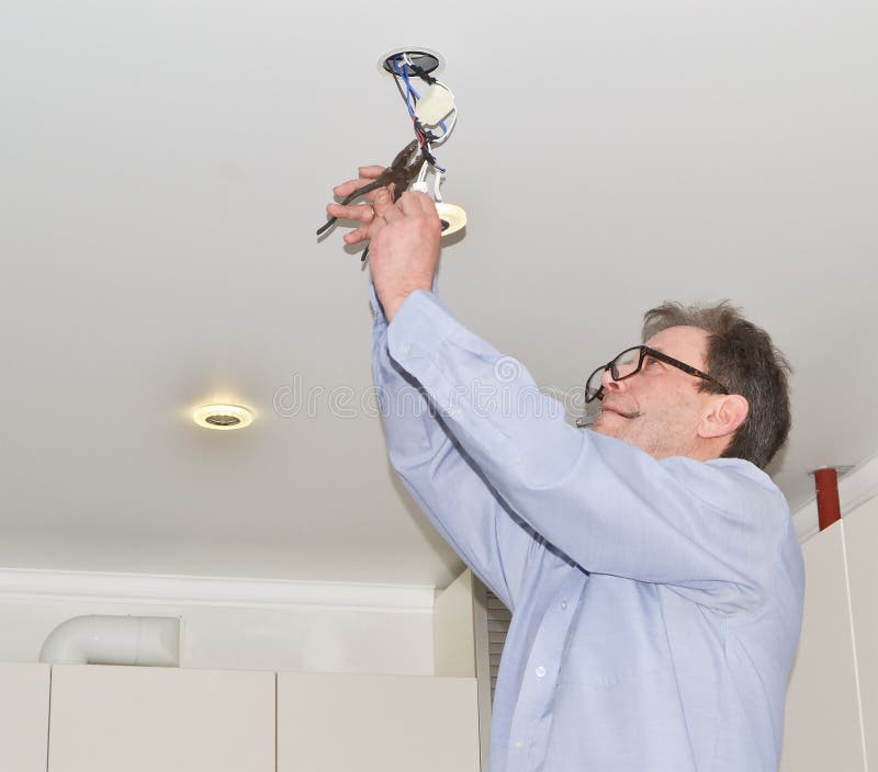 A handsome man is repairing electrical wiring and LED lights. Electrician master gives lighting to the apartment royalty free stock images A handsome man is repairing electrical wiring and LED lights. Electrician master gives lighting to the apartment royalty free stock images