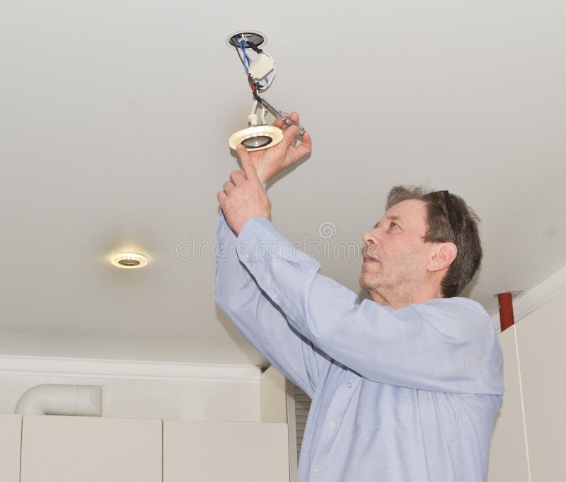A handsome man is repairing electrical wiring and LED lights. Electrician master gives lighting to the apartment royalty free stock images A handsome man is repairing electrical wiring and LED lights. Electrician master gives lighting to the apartment royalty free stock images
