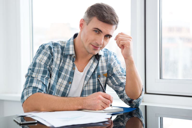 Handsome Man Sitting at the Table and Writing Stock Photo - Image of ...