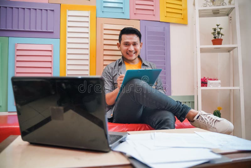 Handsome Man Smiling While Writing And Working Using Laptop Stock Image Image Of Office Asian