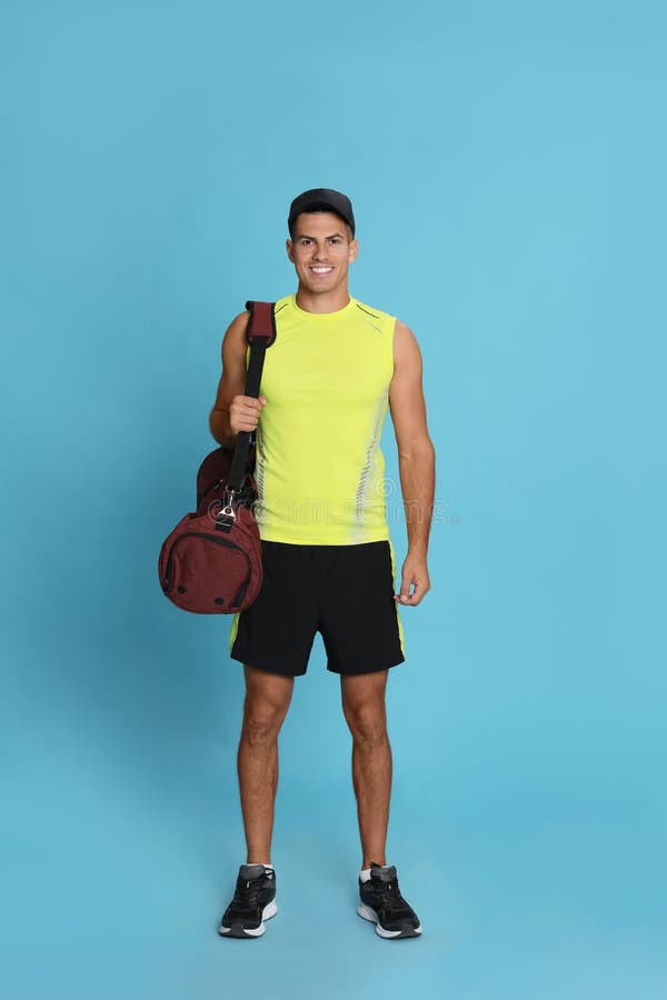 Handsome Man with Sports Bag on Light Blue Background Stock Image