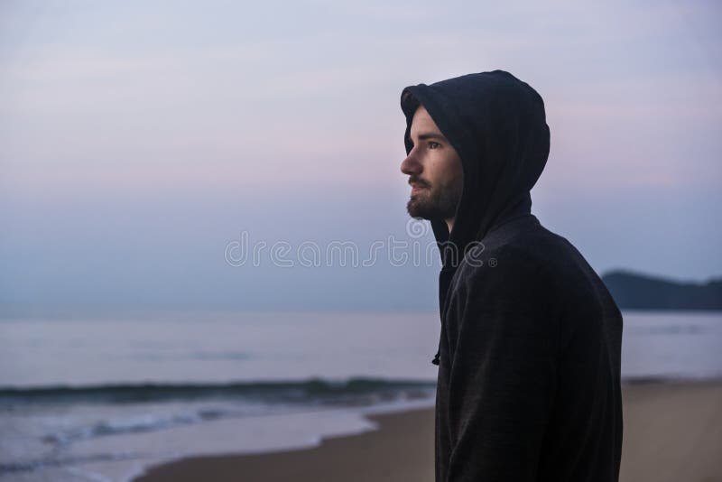 Handsome man walking in solitude at the beach