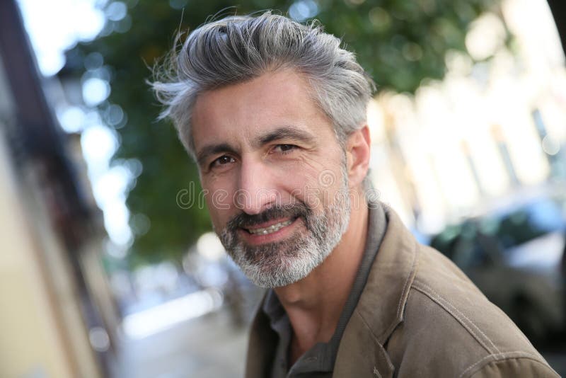 Handsome mature man walking outdoors stock image