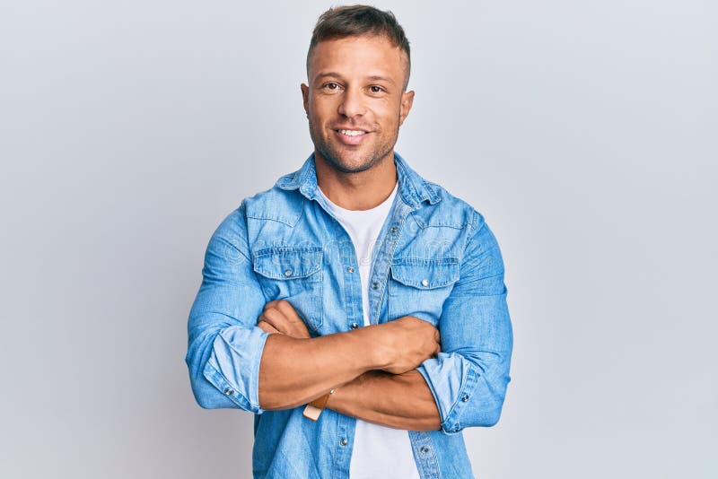 Handsome muscle man wearing casual denim jacket happy face smiling with crossed arms looking at the camera