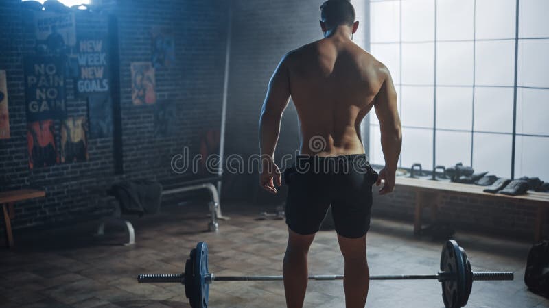 Handsome Muscular Man Does Overhead Deadlift with a Barbell in a Small Authentic Gym. Athletic royalty free stock images