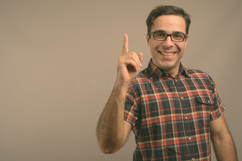 Handsome Persian man wearing eyeglasses against gray background stock images Handsome Persian man wearing eyeglasses against gray background stock images