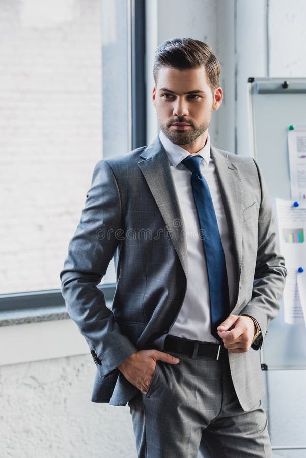 Handsome Serious Young Businessman in Suit Standing with Hand in Pocket ...