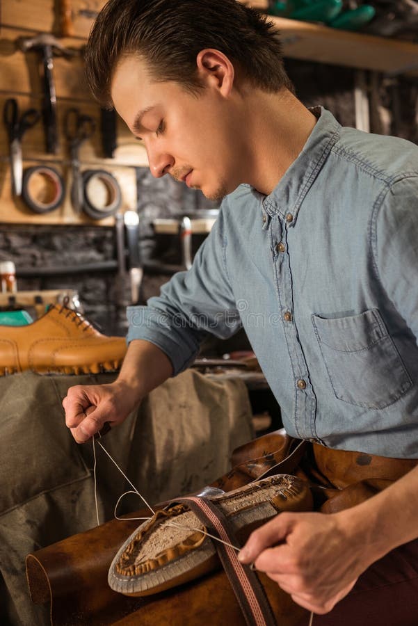 Page 7. Page 9. Handsome shoemaker sitting in workshop making shoes. 