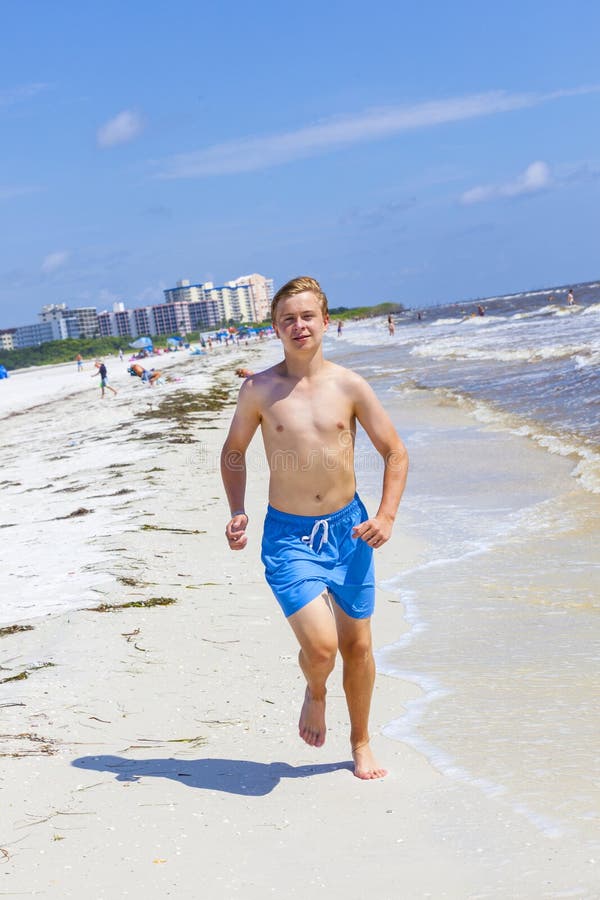 Handsome smiling boy walking at the beach