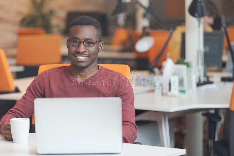 Handsome smiling successful African American man using laptop computer stock image