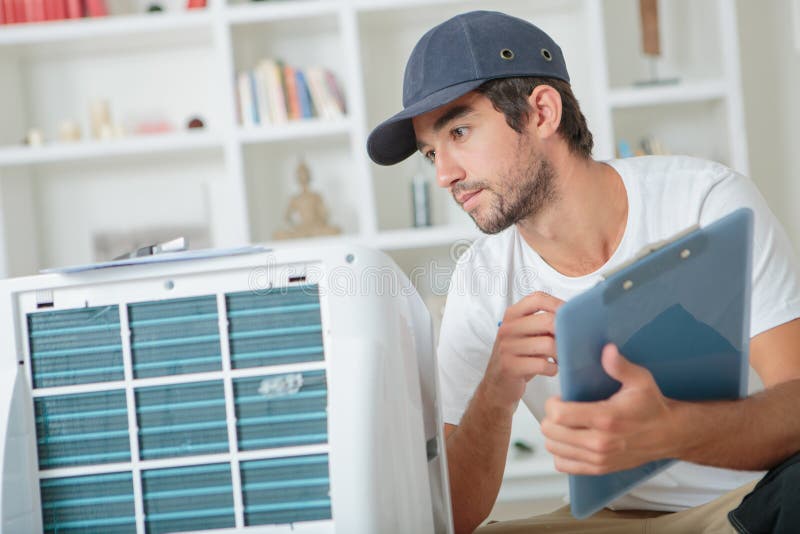 Handsome technician checking ac at clients home.