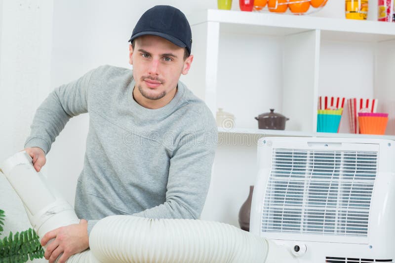 Handsome Technician Installing Airconditioner in Building Stock Photo