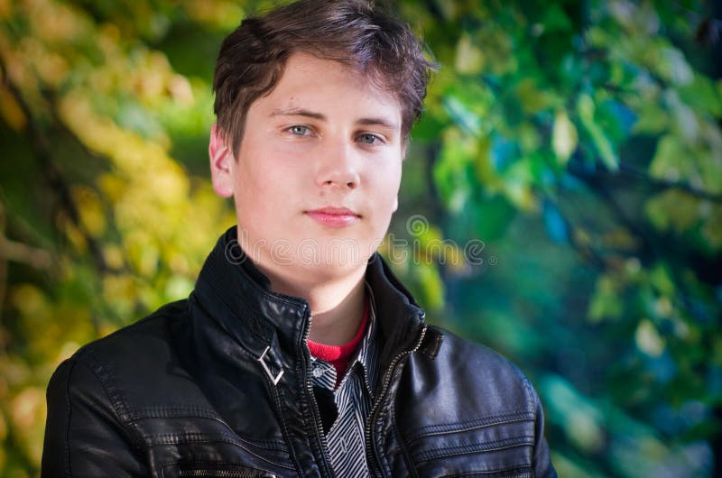 Handsome teen portrait in autumn leaves background