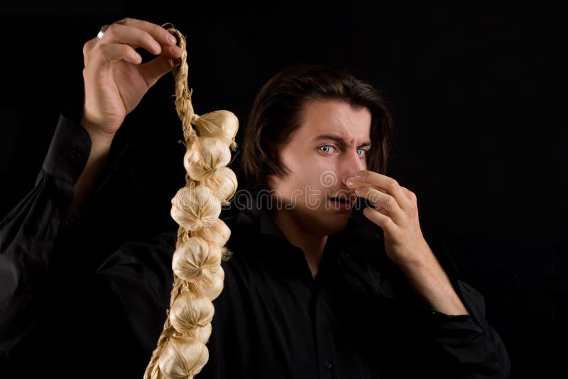 Handsome vampire doesn't like the smell of garlic royalty free stock image