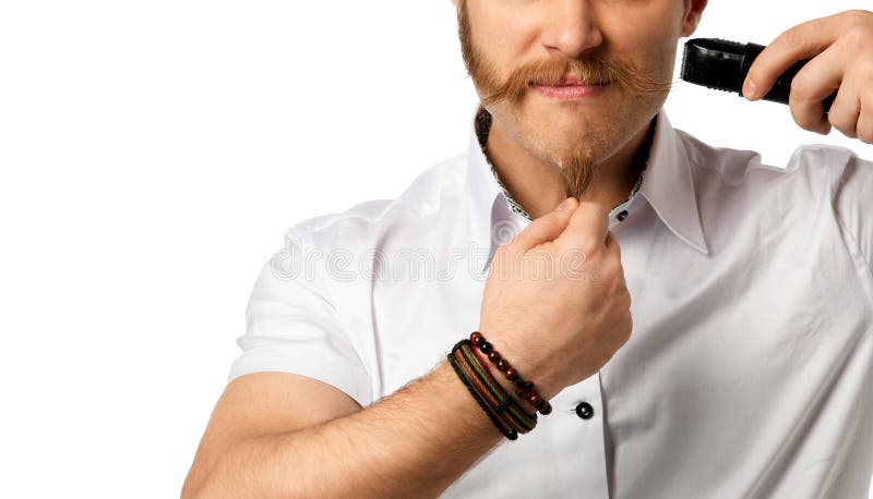 Handsome young bearded man trimming his beard with a trimmer on a white royalty free stock photo Handsome young bearded man trimming his beard with a trimmer on a white royalty free stock photo