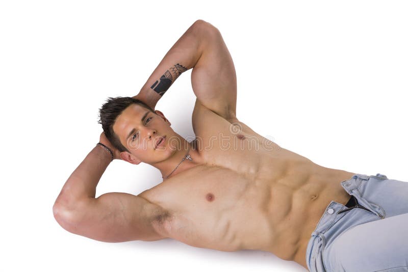 Handsome young bodybuilder laying down on the.