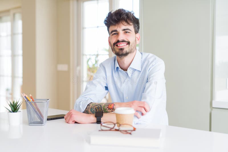 Handsome young business man smiling cheerful at the camera with crossed arms and a big smile on face showing teeth