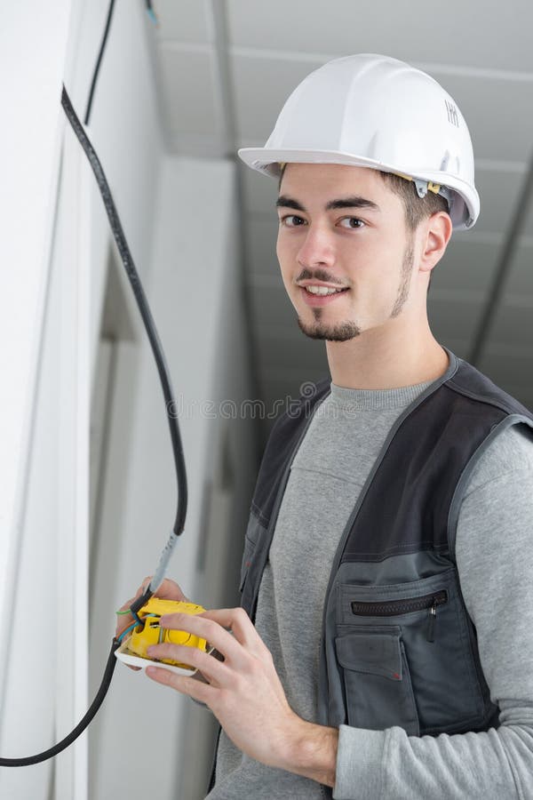 Handsome Young Electrician Working at Construction Site Stock Photo